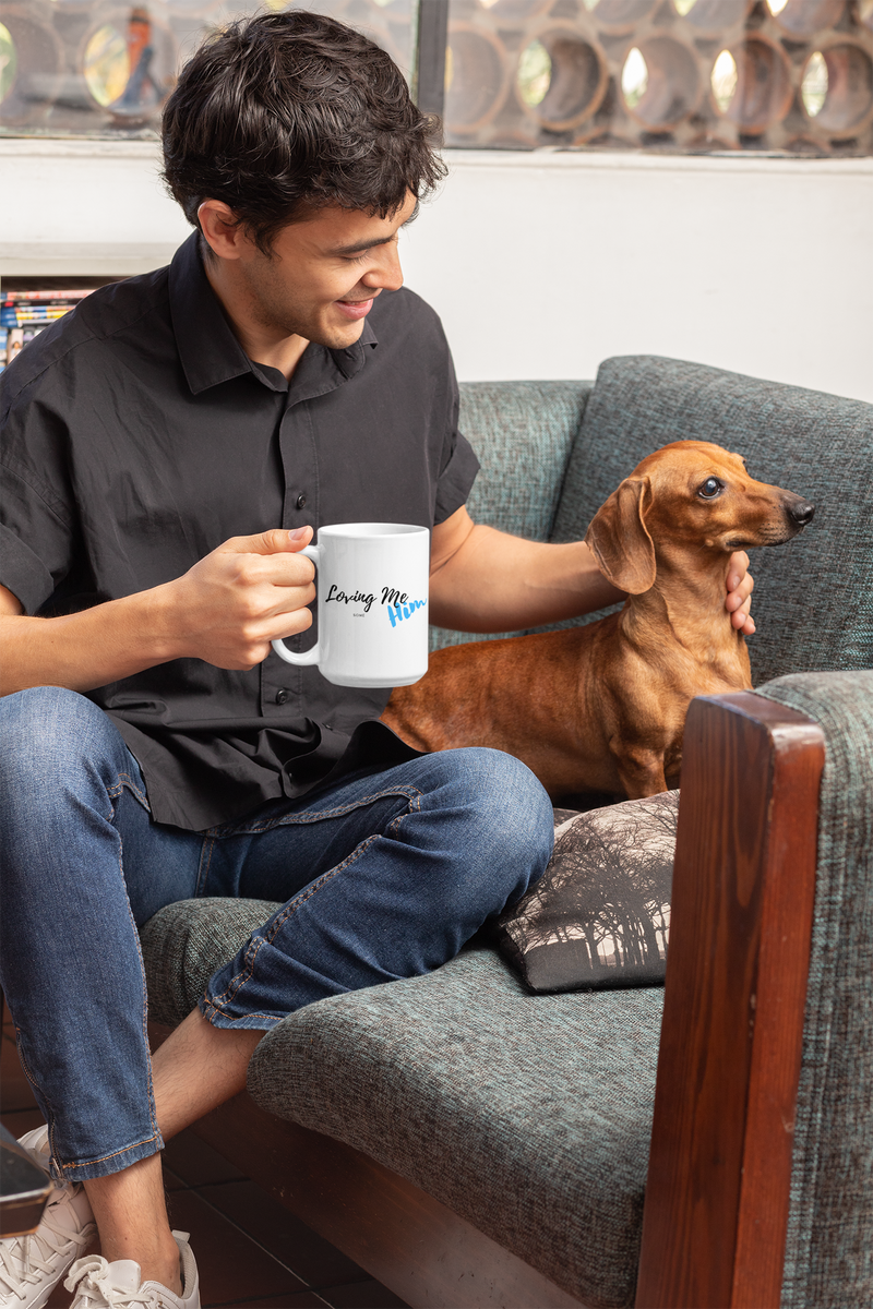 Man holding “Loving Me some him mug and petting dog